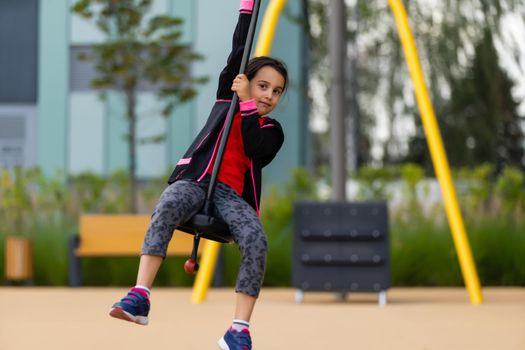 The little girl on the bungee jumping for kids outdoor.