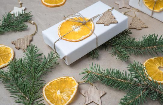 New Year's composition. Close-up gift boxes, dry orange orange slices, fir branches. Cozy Christmas concept