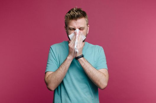 studio picture from a young man with handkerchief. Sick guy isolated has runny nose. man makes a cure for the common cold