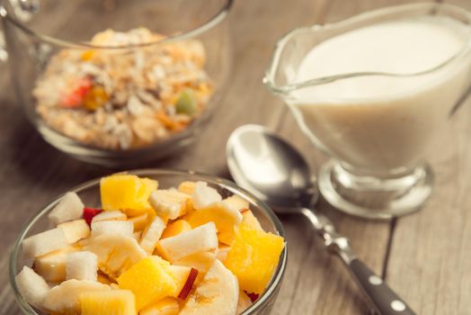 Fruit salad and muesli for breakfast on a wooden table