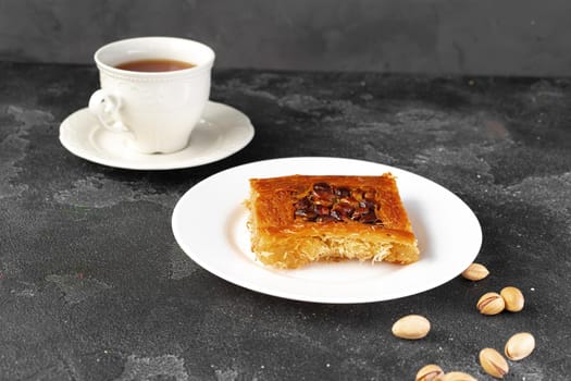 Turkish dessert baklava with nuts on black background, close up