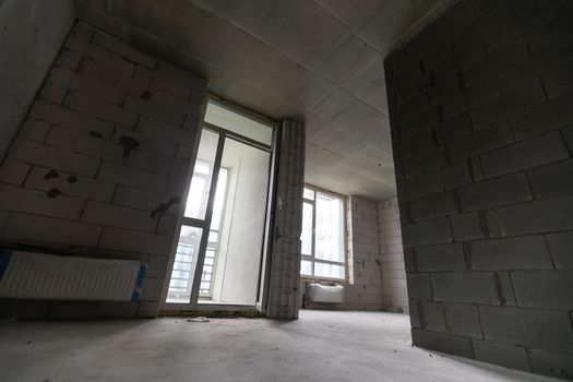 Small apartment without repair in a new building. A room in an unfinished house. Walls of foam block and concrete floor in a tiny apartment.