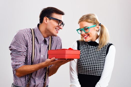 Romantic nerdy man giving present to his nerdy girlfriend.