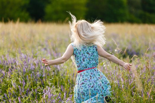 Healthy beautiful woman walking outdoors. Alluring young woman in wheat field, delicate sensual woman on nature. perfect skin, curly hair.