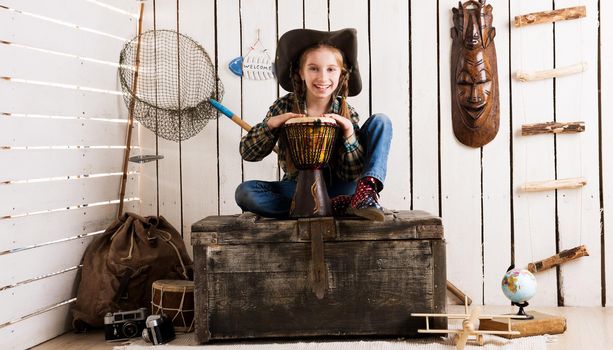 beautiful little girl in cowboy hat with drum sitting on big chest