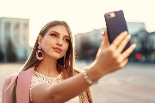Young nice woman making selfie in the street. High quality photo