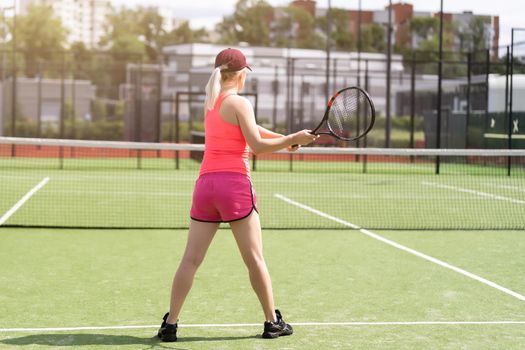 Woman playing tennis and waiting for the service