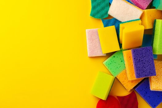 Pile of new cleaning sponges on yellow background, top view photo
