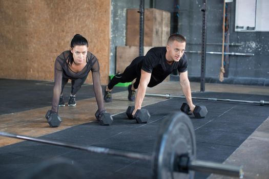 Couple doing push-ups at training in gym. Sport, fitness and healthy lifestyle concept.