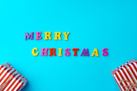 Words Merry Christmas on blue background top view, copy space