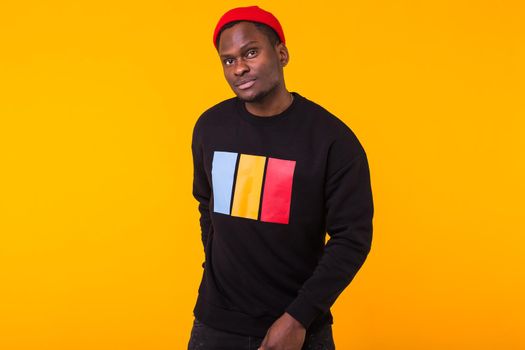 Portrait handsome young black man dressed in jeans and hoodie on white background. Street fashion and modern youth culture