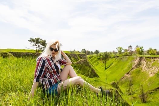 Lifestyle summer image of pretty blonde hipster woman with bag pack traveling and enjoying, stylish fresh look, happy mood, sunny colors, travel concept, emotions.