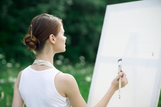 woman artist outdoors easel drawing creative landscape. High quality photo