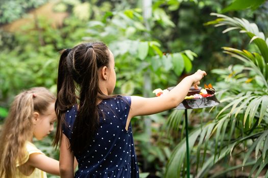 cute little girl holding living beautiful butterfly on her hand