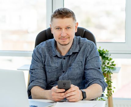 Smiling man working in light office