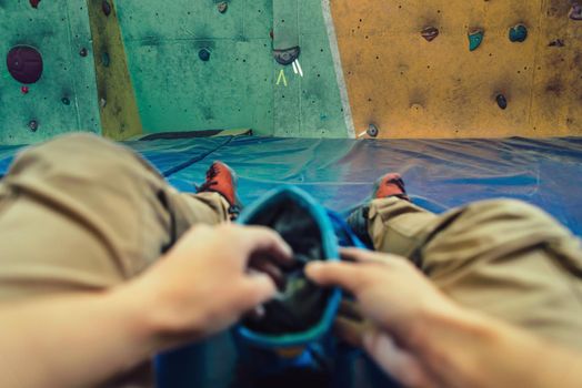 Woman putting her hand in bag of powder magnesium and preparing to climb, point of view shot