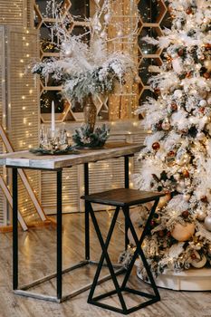 Home Christmas interior, with a Christmas tree and lots of glowing garlands and light bulbs. Preparing for the Christmas party at home.