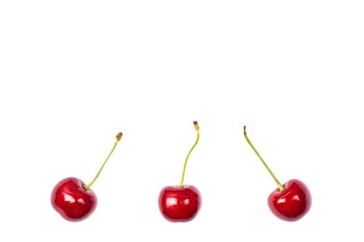 Ripe red sweet cherry isolated on white background. Macro photo close up. Three cherries on white background. Banner with copy space.