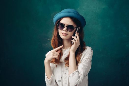 fashionable woman in blue hat with phone in hands communication technology. High quality photo