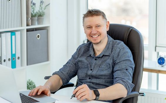 Smiling man working in light office