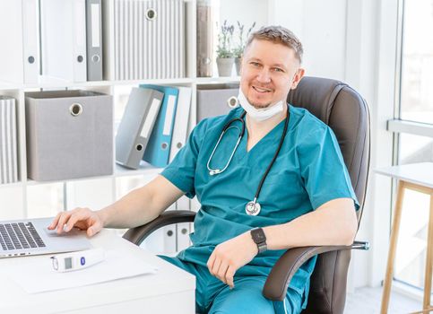 Smiling doctor wearing uniform in light office