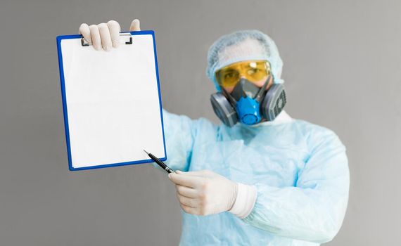 A doctor in a respirator and protective clothing shows a paper with a diagnosis. Mock up.