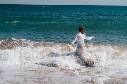 Woman in white dress freedom walk on ocean island. High quality photo