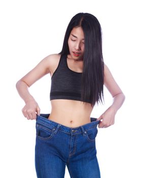 Shocked slim fitness woman in old jeans after losing weight isolated on a white background