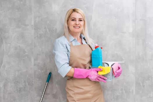 Beautiful young woman makes cleaning the house. Girl rubs dust.