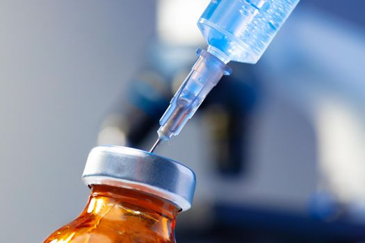 Medical vial with medication and syringe close up shot