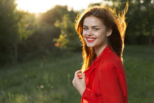 cheerful woman in a red dress in a field outdoors fresh air. High quality photo