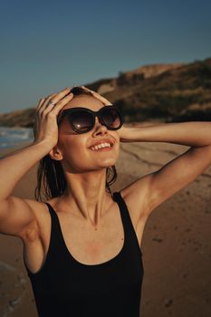 cheerful woman sunglasses posing black swimsuit island. High quality photo