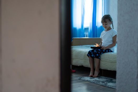 Cute young child using a digital tablet in a home interior