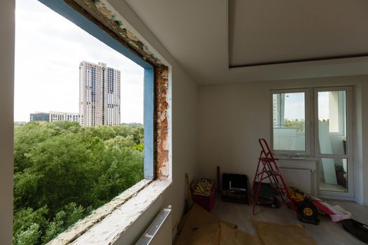 Empty frame on a wide panoramic window. Gorgeous view from the window of an apartment in a multi-storey building. Roofs of houses and trees from a height. Beautiful view through the window. Frame for