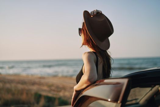 pretty woman in sunglasses near the car on the beach travel lifestyle. High quality photo