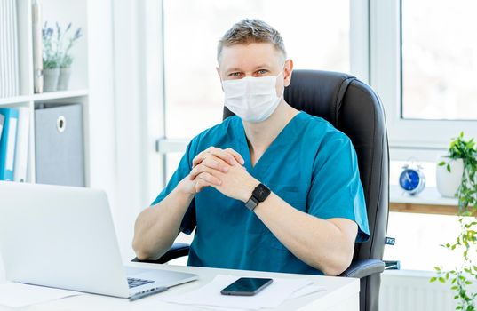 Doctor in protective mask at workplace