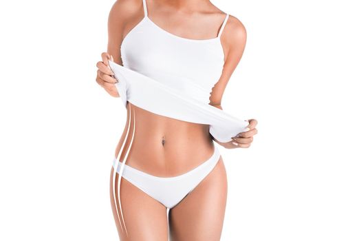 Close-up of a young woman in white underwear isolated on white background. Body correction, dieting and fat removing concept.