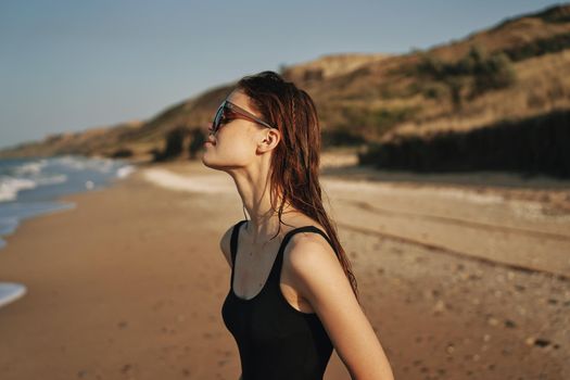 pretty woman in black swimsuit beach nature sun. High quality photo