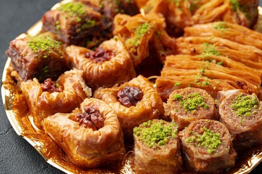 Delicious baklava dessert in oriental setting on black background, close up