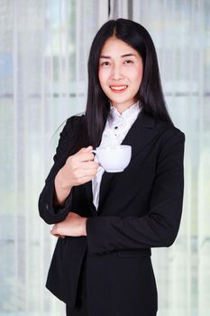 young business woman in suit with coffee or tea cup