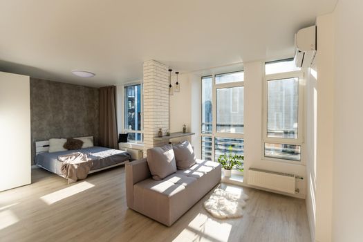 Interior of a studio apartment, wide room, bed in the foreground