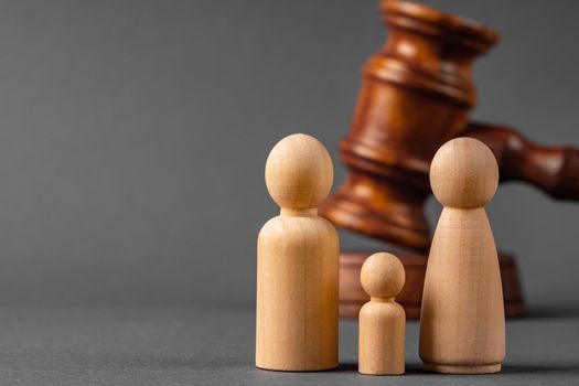 Wooden toy family and judge mallet close up. Family divorce concept