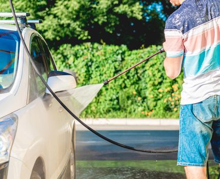 Cleaning car with water at self service car wash