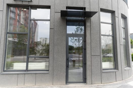 Abstract fragment of modern architecture, gray walls, glass and concrete.