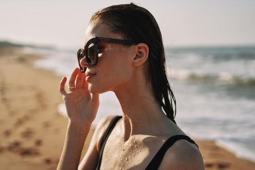 Cheerful woman black swimsuit ocean nature summer tan. High quality photo