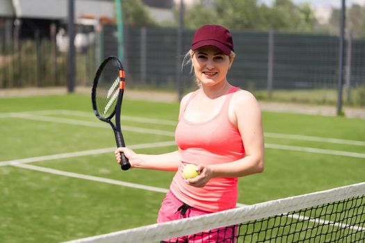 Woman playing tennis holding a racket and smiling