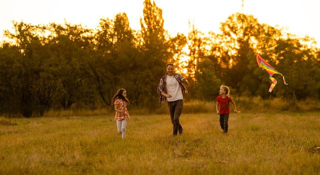 Dad with his little daughter let a kite in a field