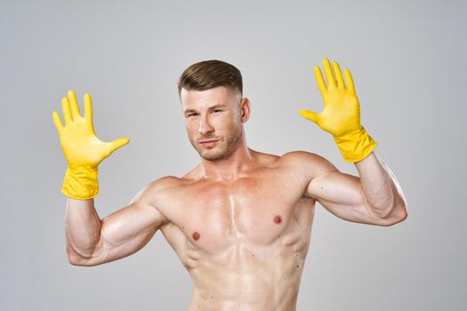 man with a pumped-up naked body in rubber gloves gesture with his hands. High quality photo