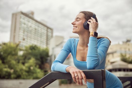 Beautiful fit caucasian woman is doing exercises outdoors at the city