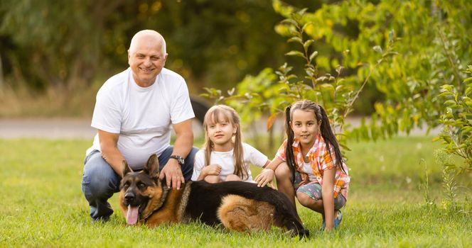 grandfather and two granddaughters are walking in the park